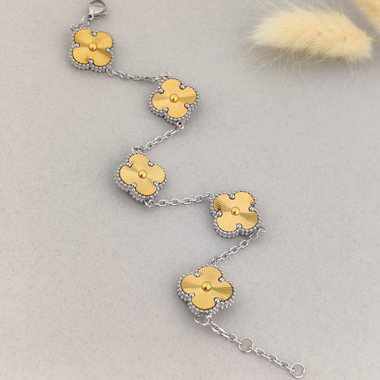 "Gold clover motif bracelet for women with silver chain links, elegant floral charm bracelet, designer four-leaf clover jewellery, luxury fashion accessory displayed on a soft grey background."