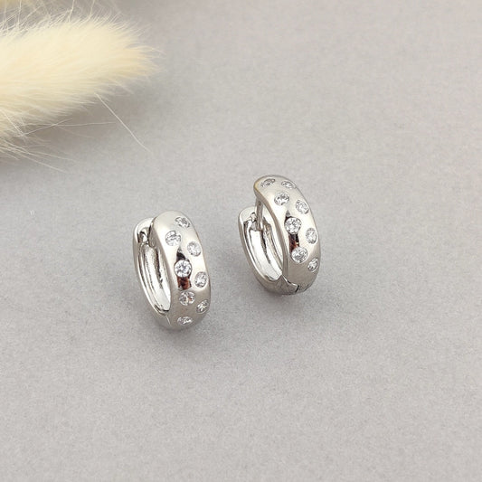 "Stylish silver hoops featuring multiple cubic zirconia accents."