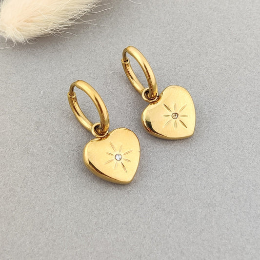 "Delicate gold hoop earrings with engraved heart pendant and CZ stone."