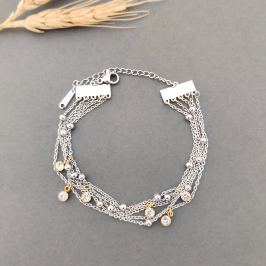“Women’s silver layered bracelet with gold-plated crystal charms and multi-chain design.”