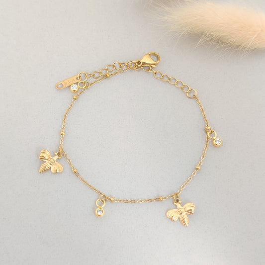 “Delicate gold bracelet featuring bee charms and sparkling CZ drops.”