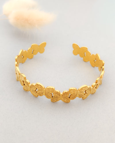 "Gold-plated floral cuff bracelet for women with textured butterfly design."